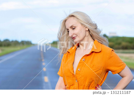 Blonde free woman is on the empty rural road in summer. Blonde free woman is on the empty rural road in summer. 131211187