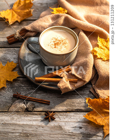 ナチュラルな木目のテーブルの上に置かれたカフェラッテと紅葉の葉  ナチュラルな木目のテーブルの上に置かれたカフェラッテと紅葉の葉  131211209