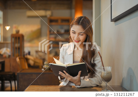 Female entrepreneur combining digital work on a laptop with handwritten notes. 131211267