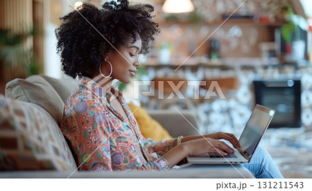Woman seated on couch using laptop for work or leisure 131211543