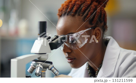 a woman is looking through a microscope in a lab 131211599