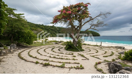 Tropical beach with a circular maze leading to a blooming tree beside blue ocean waves 131212368
