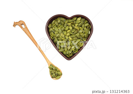Pumpkin seeds in a wooden bowl on a white background 131214363
