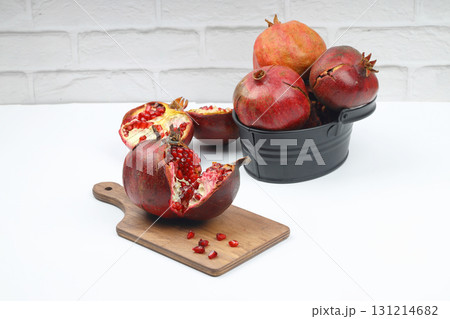 Ripe pomegranate fruit peeled on a white background top view close-up. Large open pomegranate fruit with large ripe grains isolated. Sliced exotic fruit. Ripe pomegranate fruit peeled on a white background top view close-up. Large open pomegranate fruit with large ripe grains isolated. Sliced exotic fruit. 131214682
