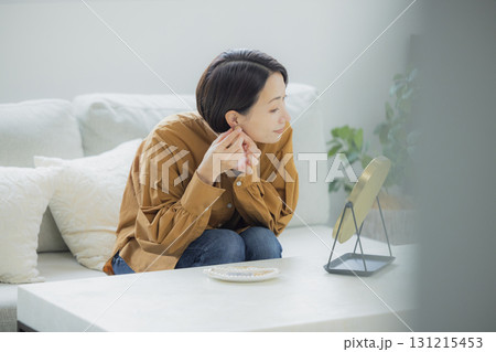 リビングで鏡を見る女性 リビングで鏡を見る女性 131215453