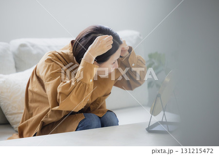 リビングで鏡を見る女性 131215472