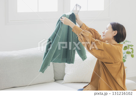 フリマアプリに出品する女性 131216102