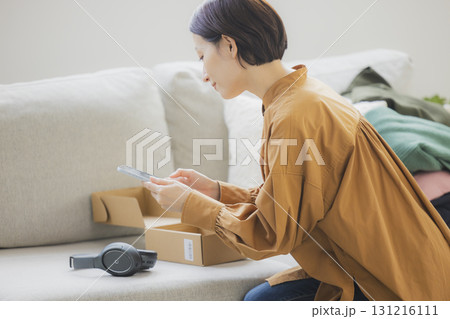 フリマアプリに出品する女性 131216111