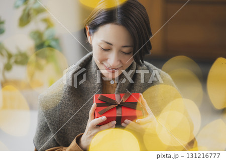 プレゼントを持つミドル女性 131216777