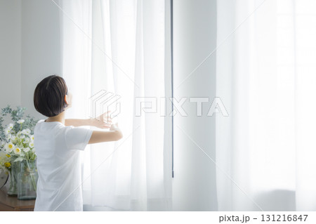 カーテンを開ける女性 131216847