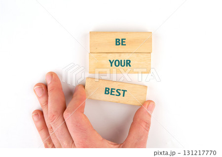 Business motivational concept. Copy space. Words BE YOUR BEST made from blocks by hand on a light background, top view 131217770