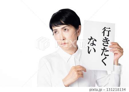 行きたくないと書かれた紙を持ち考えるシニア女性 131218134