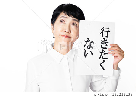 行きたくないと書かれた紙を持ち困った表情のシニア女性 131218135