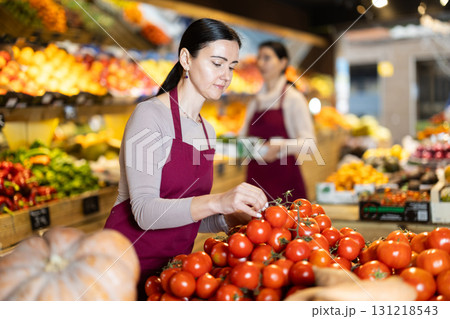 Woman staff with tomato working in greengrocery 131218543