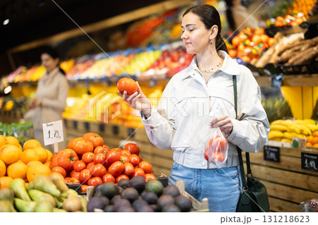 In vegetable store, young woman customer buy tomato In vegetable store, young woman customer buy tomato 131218623