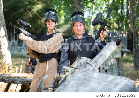 Two smiling paintball players in full gear having fun before game Two smiling paintball players in full gear having fun before game 131218655
