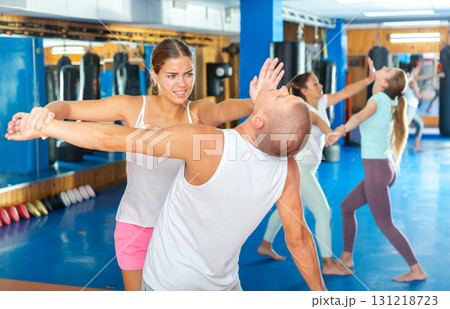 Young woman practicing self defence techniques with coach Young woman practicing self defence techniques with coach 131218723