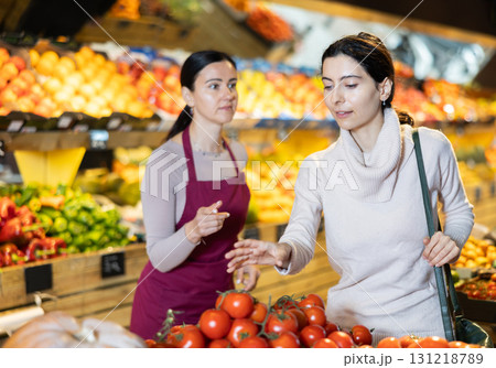 visitor discusses tomatoes with a seller visitor discusses tomatoes with a seller 131218789