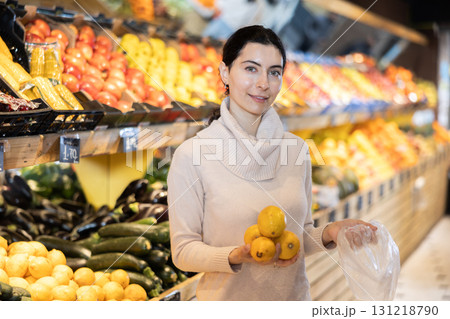 In vegetable store, young woman customer buy banana 131218790