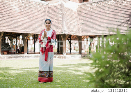 A woman in traditional attire stands in front of a historical building, showcasing cultural heritage and architecture. A woman in traditional attire stands in front of a historical building, showcasing cultural heritage and architecture. 131218812