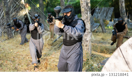 Impudent teams facing on battlefield in outdoor paintball arena during match 131218841