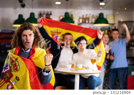 Joyful fans of the Spain team celebrating the victory in night bar Joyful fans of the Spain team celebrating the victory in night bar 131218904