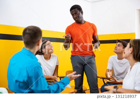 Student group lively discussing while sitting in circle in auditorium 131218937