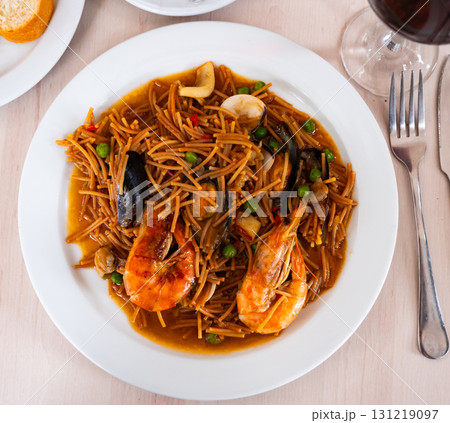 Pasta with seafood contains tiger prawns, shell mussels, spices and white sauce 131219097