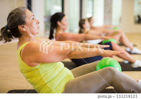 Group of women doing roll ups with bener balls Group of women doing roll ups with bener balls 131219121