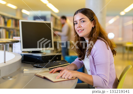 Young woman working with book and computer 131219141