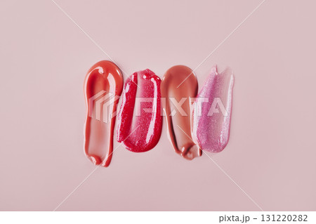 Different lip gloss strokes on pink pastel background 131220282