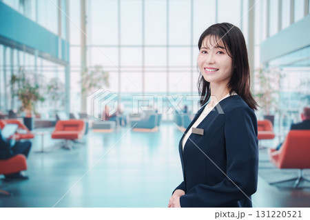 空港で接客をする若い女性スタッフ	Young female staff serving custo 131220521