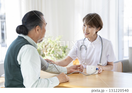 シニア男性の血圧を測る医療スタッフ 131220540