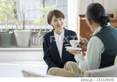 シニア男性と話すベテランの女性施設スタッフ シニア男性と話すベテランの女性施設スタッフ 131220830