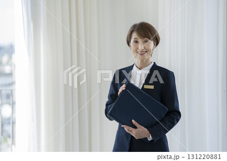 カメラ目線の50代の女性スタッフ 131220881