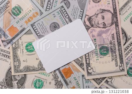The white plastic card as a symbol of cashless payments on the background of cash paper money of USA The white plastic card as a symbol of cashless payments on the background of cash paper money of USA 131221038