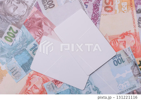 The white plastic card as a symbol of cashless payments on the background of cash paper money of Brazil The white plastic card as a symbol of cashless payments on the background of cash paper money of Brazil 131221116