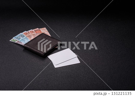 The white plastic card as a symbol of cashless payments on the background of cash paper money of Brazil The white plastic card as a symbol of cashless payments on the background of cash paper money of Brazil 131221135