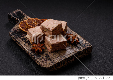 Nougat or white caramel with hazelnuts and pistachios and citrus pieces. White nougat with nuts 131221282