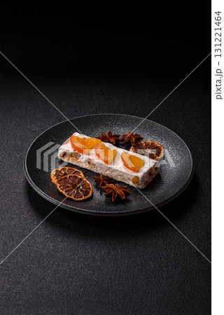 Nougat or white caramel with hazelnuts and pistachios and citrus pieces. White nougat with nuts 131221464