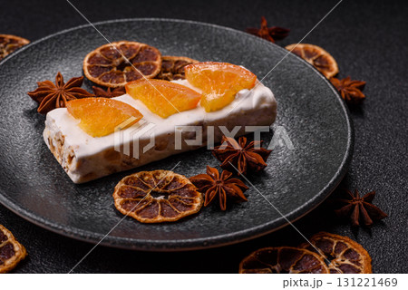 Nougat or white caramel with hazelnuts and pistachios and citrus pieces. White nougat with nuts 131221469