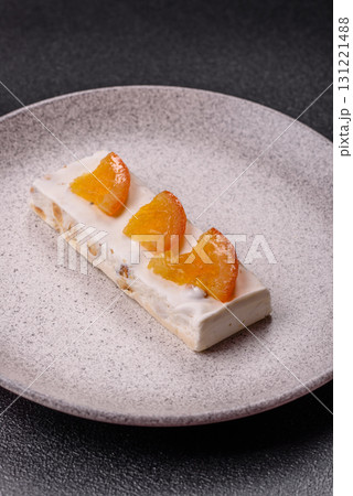 Nougat or white caramel with hazelnuts and pistachios and citrus pieces. White nougat with nuts 131221488