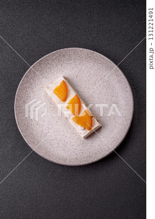 Nougat or white caramel with hazelnuts and pistachios and citrus pieces. White nougat with nuts 131221491