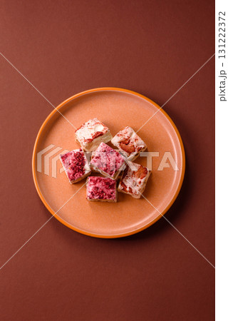 Nougat or white caramel with hazelnuts and strawberry pieces. White nougat 131222372