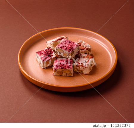 Nougat or white caramel with hazelnuts and strawberry pieces. White nougat Nougat or white caramel with hazelnuts and strawberry pieces. White nougat 131222373