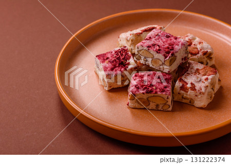 Nougat or white caramel with hazelnuts and strawberry pieces. White nougat Nougat or white caramel with hazelnuts and strawberry pieces. White nougat 131222374
