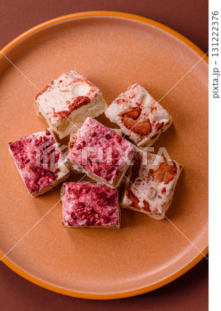 Nougat or white caramel with hazelnuts and strawberry pieces. White nougat 131222376