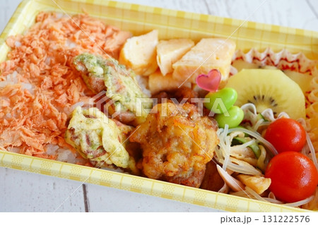 鮭フレークご飯と唐揚げや卵焼きが入った彩り豊かで美味しそうな手作り弁当 鮭フレークご飯と唐揚げや卵焼きが入った彩り豊かで美味しそうな手作り弁当 131222576