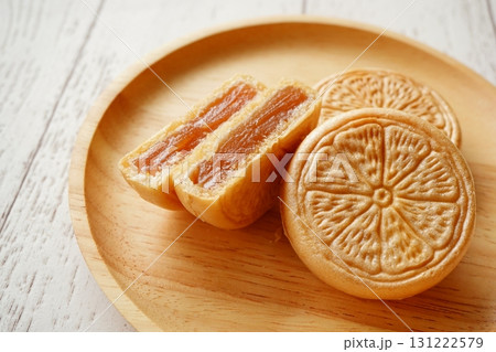 木の器に並べられた柑橘模様の皮に餡がぎっしり詰まった最中の和菓子の写真 木の器に並べられた柑橘模様の皮に餡がぎっしり詰まった最中の和菓子の写真 131222579