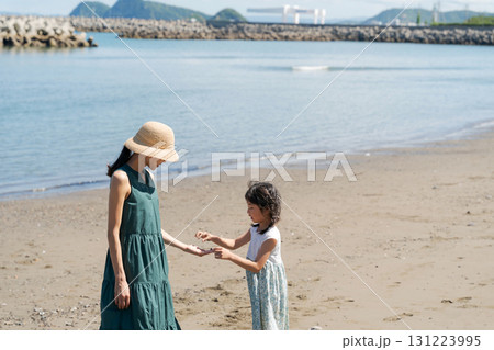 波打ち際で遊ぶ家族 131223995